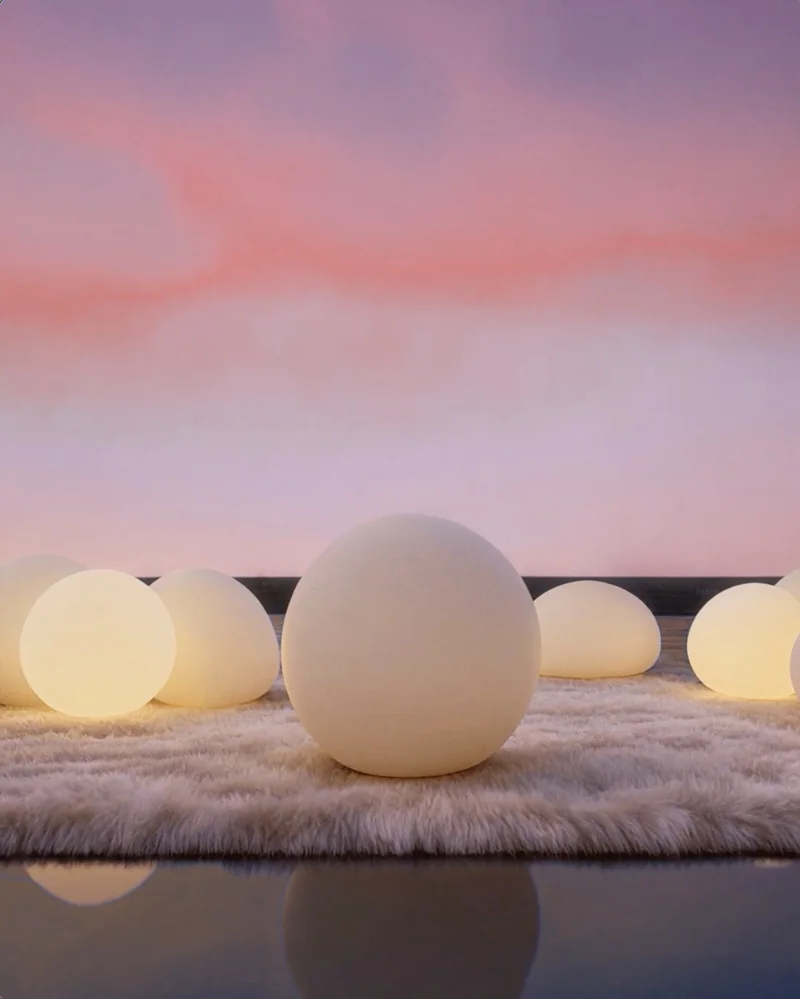 Soft glowing orbs on a rug at dusk, one slowly pulsing