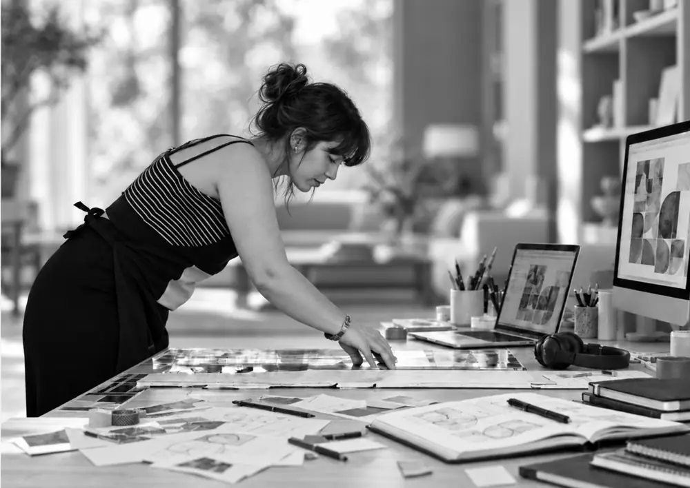 Ida Dilfer at her studio table, laying out prints